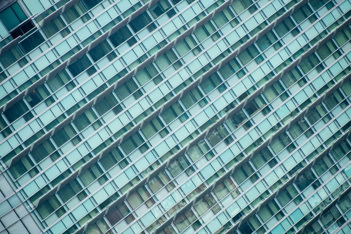 Intersecting glass façades reflecting light and sky
